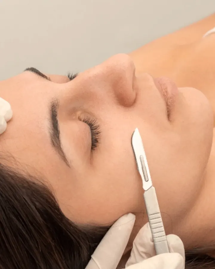 Esthetician scraping dead skin cell layers